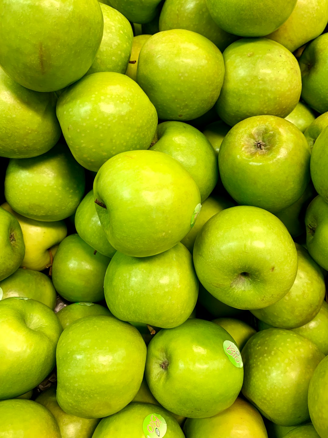 Fresh green apples packed tightly together.